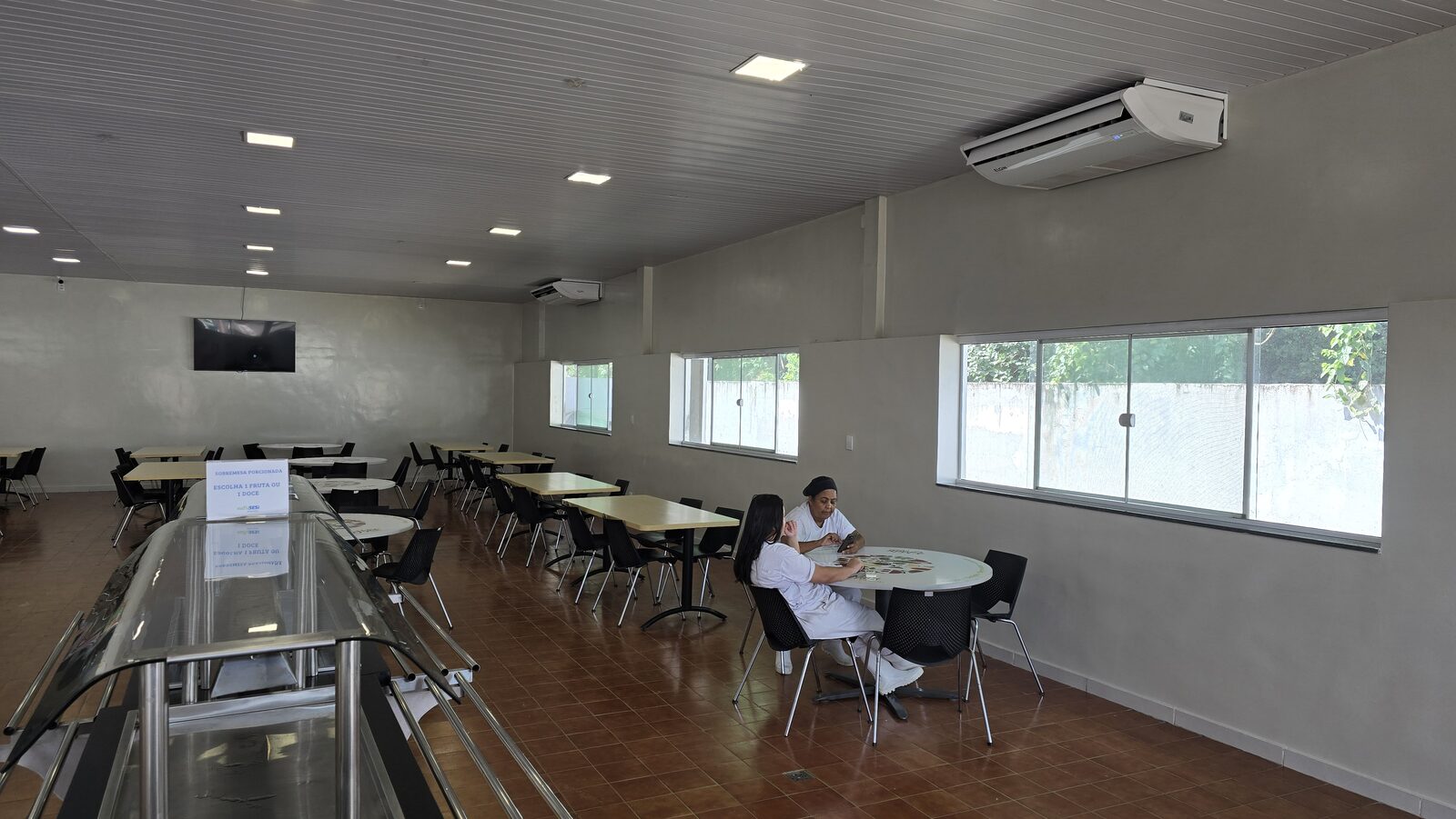Linha de distribuição de refeições com balcões térmicos em inox, tampo de granito e protetores salivares de vidro